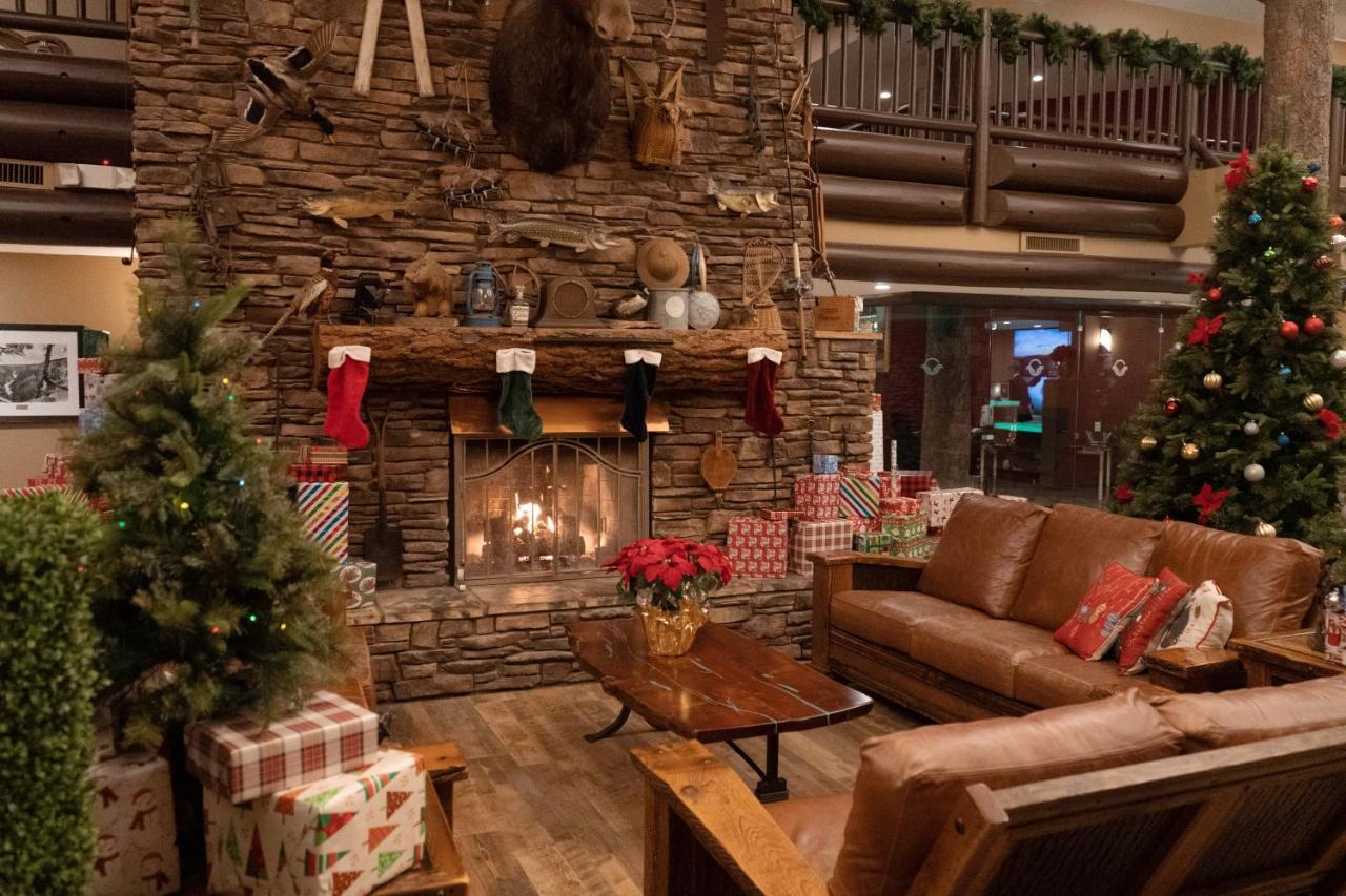 The Grand Hotel At The Grand Canyon Tusayan Dış mekan fotoğraf The photo depicts a cozy interior setting, likely a lodge or cabin, decorated for the holiday season. In the center, there is a stone fireplace with a roaring fire, adorned with festive stockings hanging from the mantel. Above the fireplace, there ar