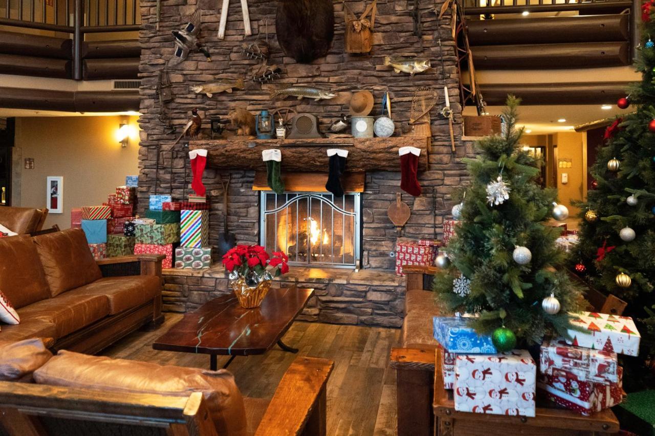 The Grand Hotel At The Grand Canyon Tusayan Dış mekan fotoğraf The photo depicts a cozy lodge-like interior, highlighted by a large stone fireplace at the center. Above the fireplace, there are various decorative items, including fishing gear and a mounted animal head. The fireplace is adorned with colorful Chri